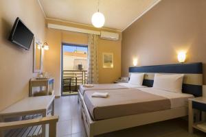 a hotel room with two beds and a balcony at Rea Hotel in Palaiochora