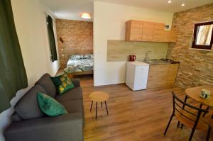 een woonkamer met een bank en een tafel en een keuken bij Ginko House in Opatija