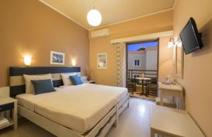 a bedroom with a large bed and a balcony at Rea Hotel in Palaiochora
