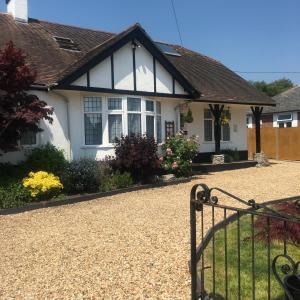 a white house with a gate in front of it at Spurwing Guest House in Wareham