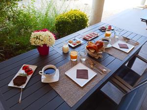 - une table de pique-nique avec des aliments pour le petit-déjeuner et des boissons dans l'établissement Chambres d'hôtes Le Mas de Molines, à Vogüé