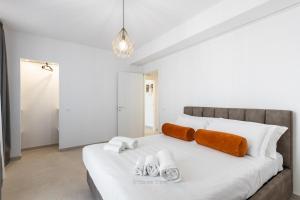 - une chambre avec un lit blanc et des serviettes dans l'établissement House & Villas - Boutique Apartments, à Avola