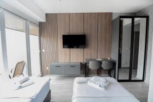 a hotel room with a bed and a tv on a wall at Leon Luxury Apartments in Ohrid