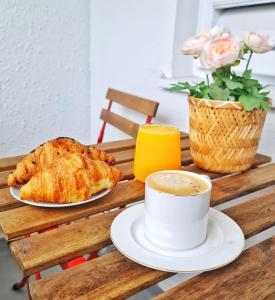 a table with a cup of coffee and a croissant at Arc de Triomphe BlissBoutique in Bucharest