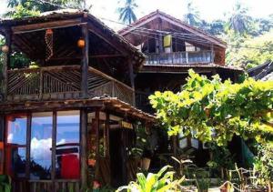a wooden house with a balcony on the side of it at Pousada Boas Ondas in Itacaré