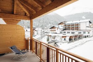 a chair on a balcony with a view of a town at Hotel Bambi Am Park in Solda