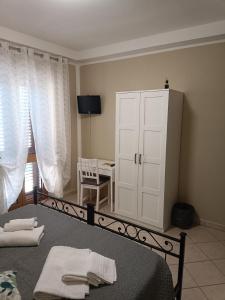 Un dormitorio con una cama y un armario con toallas. en Il Roseto, en Coppito