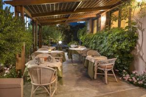 a restaurant with tables and chairs on a patio at Rea Hotel in Palaiochóra