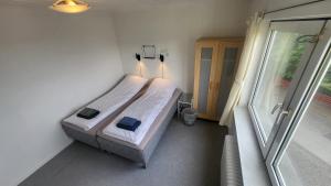 um quarto com uma cama num quarto com uma janela em Heart of the City (Hotel Bólið Guesthouse) em Tórshavn