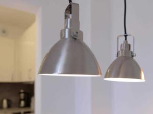 two lights hanging from a wall in a kitchen at Ohlerich Speicher App_ 05 in Wismar