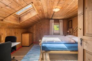 a bed in a room with a wooden ceiling at Enrich Apartment in Ortisei