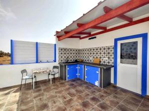 cocina con armarios azules, mesa y sillas en Suite Estrella Azul en Gran Tarajal
