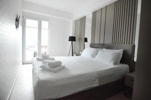 ein Schlafzimmer mit einem weißen Bett und Handtüchern darauf in der Unterkunft Leon Luxury Apartments in Ohrid