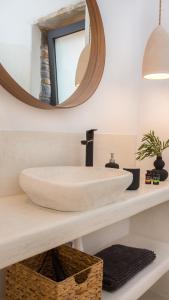 uma casa de banho com um lavatório branco e um espelho. em MYRTOS em Caristo