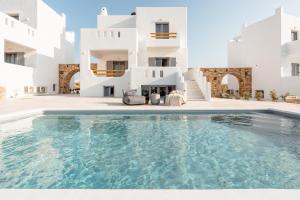 a swimming pool in front of a white building at Nymphée Luxury Villas in Agia Anna Naxos