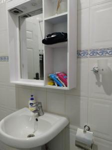 a bathroom with a white sink and a mirror at Atlantic Court Apartment in Abuja