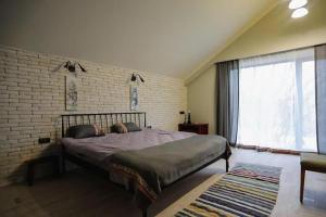 a bedroom with a large bed and a brick wall at Cuib Complex Turistic in Căpriana