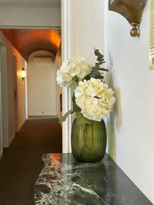 un jarrón lleno de flores blancas sentadas en un mostrador en Hotel Joao Padeiro, en Aveiro