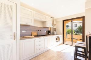een keuken met witte kasten en een groot raam bij Beautiful furnished apartment in a private Residence with Pool in Cannes