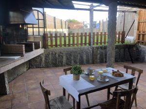 a white table and chairs on a patio at A Casa de Abaixo in Cuntis