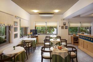 a restaurant with tables and chairs in a room at Rea Hotel in Palaiochora