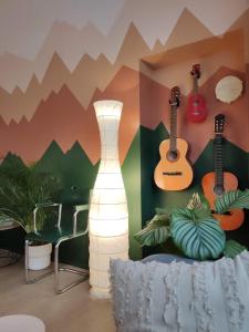 Bamboo Eco Hostel في تورينو: غرفة بها قيثارات على الحائط ومصباح