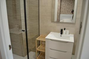 een badkamer met een witte wastafel en een douche bij Inmoinsuas Calle Greco 8 in Sarria