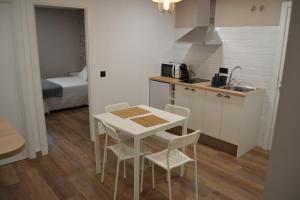 een keuken met een tafel en stoelen in een kamer bij Inmoinsuas Calle Greco 8 in Sarria