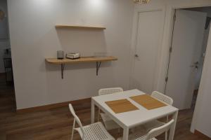 una mesa blanca y sillas en una habitación en Inmoinsuas Calle Greco 8, en Sarria