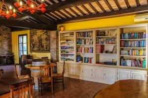 una biblioteca con armarios blancos, mesas y estanterías en Agriturismo Dandelion, en Città della Pieve