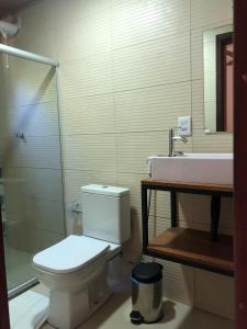 a bathroom with a toilet and a sink at Villaflor Pousada in Vale do Capao