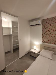 ein Schlafzimmer mit einem Bett und einer roten Wand in der Unterkunft La Villa Yucca Vias Plage - 300m plage et centre in Vias