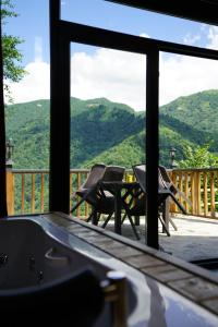 a room with a view of a table and chairs on a balcony at LUSER BUNGALOW in Ardeşen