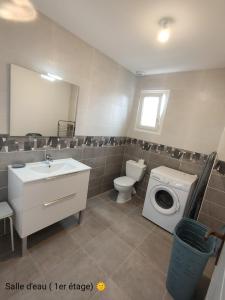 a bathroom with a toilet sink and a washing machine at La Villa Yucca Vias Plage - 300m plage et centre in Vias