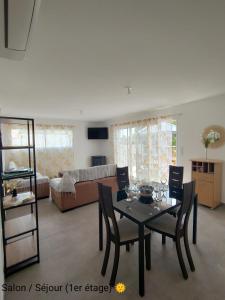 ein Wohnzimmer mit einem Tisch, Stühlen und einem Sofa in der Unterkunft La Villa Yucca Vias Plage - 300m plage et centre in Vias