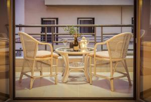 een tafel met twee stoelen en een tafel met een vaas bij Rea Hotel in Palaiochóra