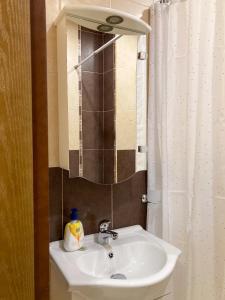 een badkamer met een wastafel en een spiegel bij Уютен кът in Boergas