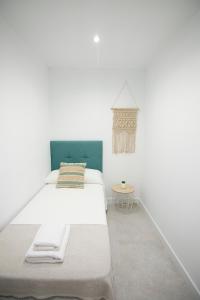 biała sypialnia z łóżkiem i stołem w obiekcie Clotilde Centro w mieście Alcañiz
