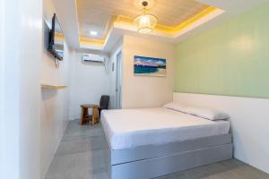 a bedroom with a bed and a tv in it at Bamboo Paraiso Resort at Bolo Beach in Alaminos
