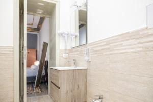 a bathroom with a sink and a mirror at Borgo Antico Rooms in Messina