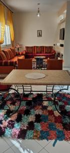 a living room with a table and a rug at appartement julia au centre ville agadir dans résidence borj dalat in Agadir