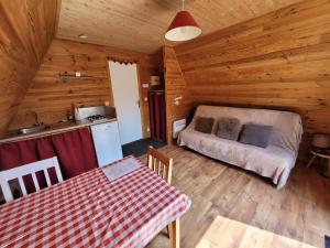 a kitchen and a bedroom in a log cabin at Camping les Hirondelles in Bourg-Sainte-Marie