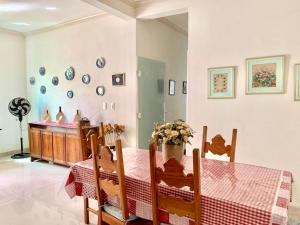 a dining room with a table and some plates on the wall at Casa João do Táxi in Tiradentes
