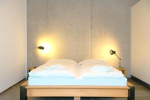 Bett in einem Zimmer mit zwei Leuchten in der Unterkunft Eiger in Spiez