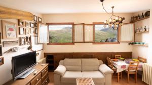 a living room with a tv and a chair and a table at Apartamentos Formigal - Admite mascotas- in Formigal