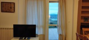 un televisor sentado en una mesa frente a una ventana en La Casuca de Suances, en Suances