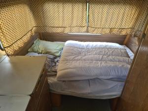 un letto sul retro di una piccola camera di Camping à la ferme - Hébergements insolites a Cerisy-la-Forêt
