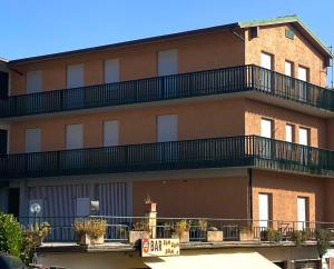 ein Gebäude mit einem Balkon an der Seite in der Unterkunft Umbria Green Central Rooms in Castiglione del Lago