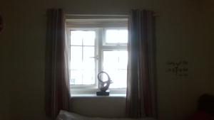 a window in a bedroom with a fan on a window sill at Small but bright single room not far from City Centre in Leicester