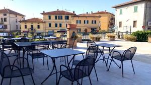 eine Gruppe von Tischen und Stühlen mit Gebäuden im Hintergrund in der Unterkunft Umbria Green Central Rooms in Castiglione del Lago